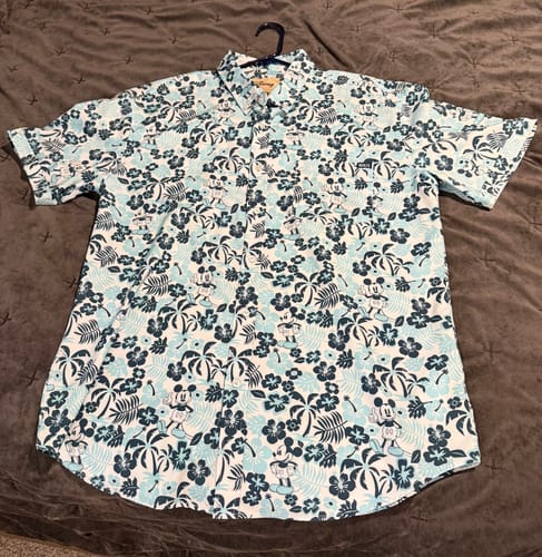 Customer's blue 'Aloha Pal' shirt laid flat, showing the detailed Mickey Mouse and palm tree pattern.