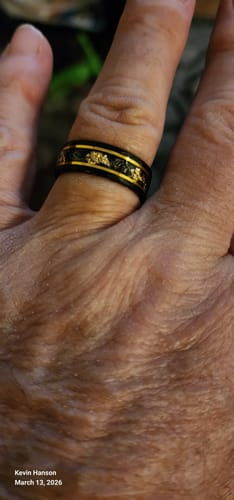 Customer's hand wearing the black Titanfall ring with a gold flake and meteorite inlay.
