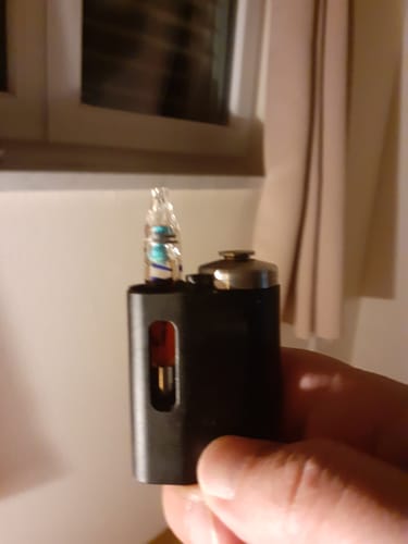 Kunde hält die THC Lemon Haze Vape Kartusche in einem schwarzen Vape-Gerät in der Hand.