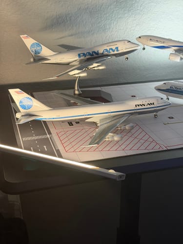 Reviewer's collection of two detailed Pan American 747SP model airplanes displayed on a desk.