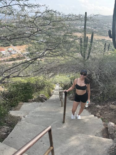 Reviewer wearing the black Ballet Bralette while pausing on a long flight of outdoor stairs.