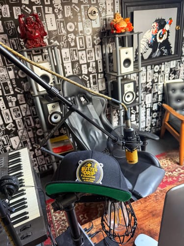 Reviewer's black Image Hat Round with a custom patch and green undervisor, seen in a music studio.