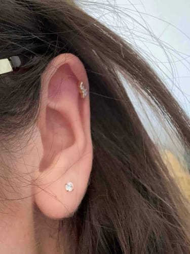 Reviewer showing the Midi Solitaire flatback Gold stud in their earlobe, stacked with another earring in the cartilage.