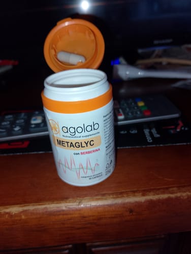 Recensore mostra il flacone di Metaglyc aperto con una capsula nel tappo arancione.