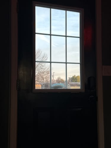 Customer's Grills Between Glass 9 Lite kit installed on the top half of a dark door.