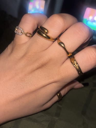 Customer's hand wearing several stylish gold-colored rings.