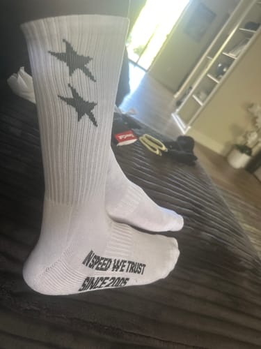Customer wearing white ALL-STAR CREW SOCKS, showing the two black stars on the calf and text on the sole.