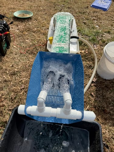 Reviewer's Double Mat Sluice Box in a power sluice configuration, with water flowing into the blue hopper outdoors.
