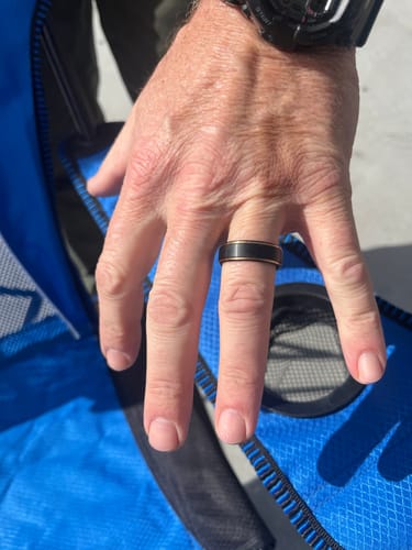 Customer's hand wearing the black Osiris ring with distinctive rose gold beveled edges.