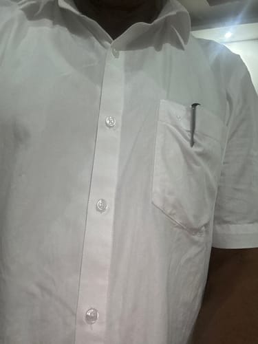Customer wearing the short-sleeved white shirt. The close-up shot shows the fit, buttons, and pocket with a pen.