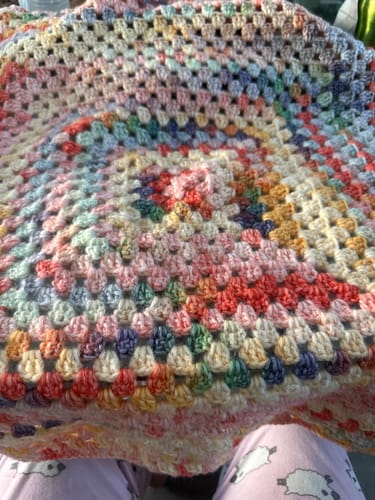 Customer's colorful Hearthside Rainbow Blanket in progress, showing the variegated yarn in a granny square pattern.