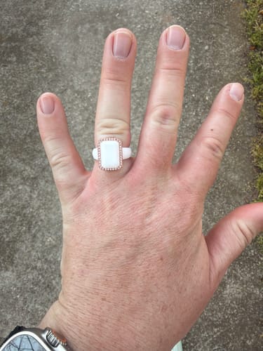 Customer's hand wearing the white Emerald Silicone Ring with a polished metal frame.
