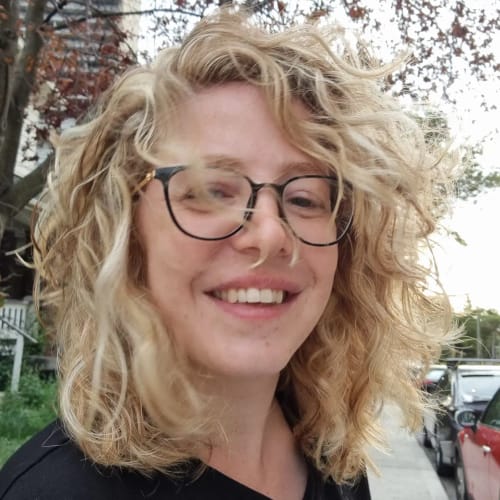 תמונת לקוחה מחייכת עם שיער בלונדיני מלא וגלי לאחר שימוש ב-Fill it Hair.