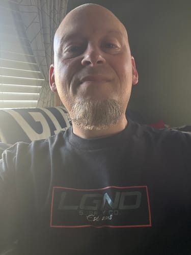 Customer taking a close-up selfie while wearing the black Cracked Sanity Tee.