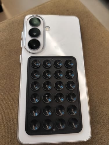 Customer's Anti Yellow Magsafe Clear Case on a white Samsung phone, with a black suction cup accessory attached to the back.
