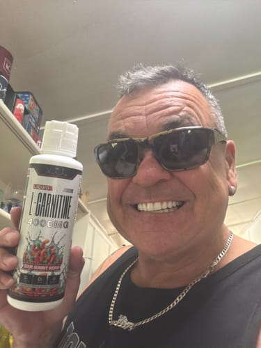 Reviewer smiling while holding a bottle of Liquid L-Carnitine 4000MG supplement.