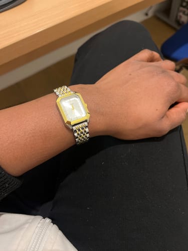 Customer showing the two-tone CLAIRE DE MAINS watch with a rectangular face on their wrist.