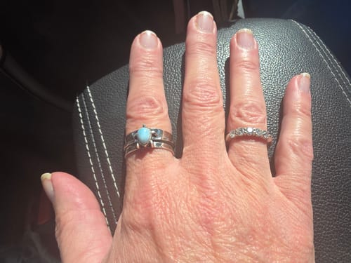Customer's hand wearing the silver Turtle Larimar Fidget Ring on their index finger.