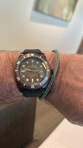 Customer's Oceaneva pro diver watch on their wrist, showing the unique aged bronze dial and black band.