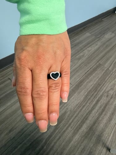 Customer's hand wearing the black silicone ring with a heart-shaped metal frame and CZ stones.