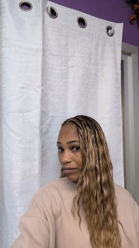 Reviewer showing her installed Mix Color Blend Loose Deep Wave hair, styled with small braids at the top.