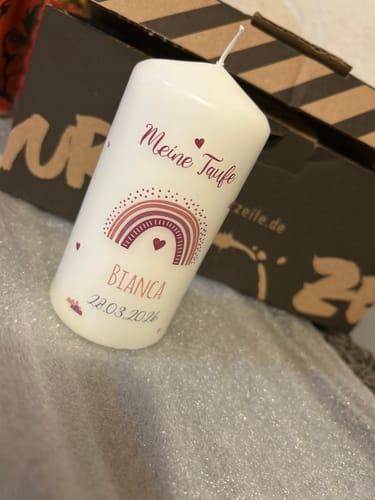 Personalisierte Taufkerze eines Kunden mit dem Aufdruck 'Meine Taufe', einem Regenbogen, dem Namen Bianca und dem Datum 28.03.2024.