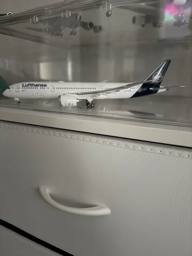 Customer's Lufthansa 787-9 model airplane displayed side-on in a clear protective case on a dresser.