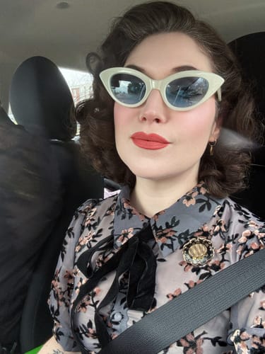 Reviewer wearing the white Fashion Doll Cat Eye Sunglasses in a car.
