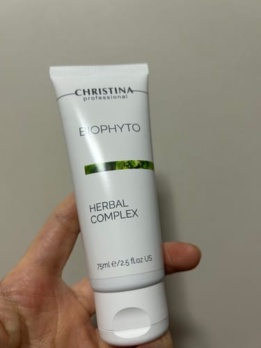 レビュアーが手に持っているハーバルコンプレックスの白いチューブ。
