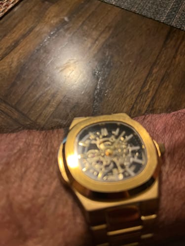 Close-up: Customer wearing the gold Lucky Fours® Skeleton watch on their wrist.