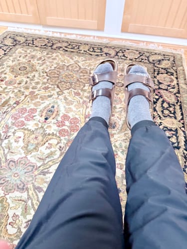Customer's first-person view of the black Palmer Joggers while relaxing indoors.