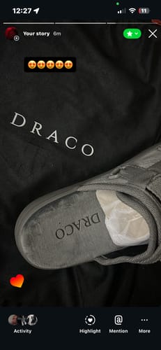Close-up of a customer's Cool Grey Dracos V2 slide next to the black branded dust bag, showing the Draco logo on both.