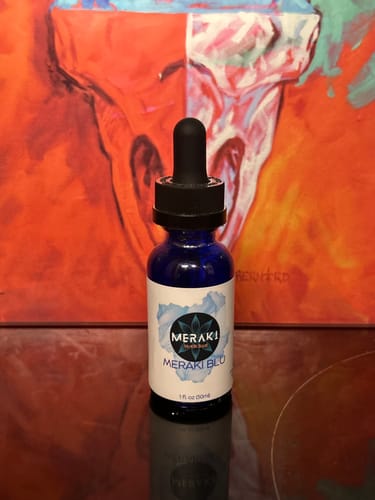 Customer's Meraki Blu Methylene Blue bottle with a dropper on a reflective surface.