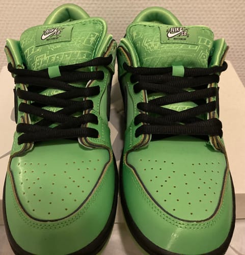 Bovenaanzicht van de Nike SB Dunk Low Buttercup sneakers, met focus op de tong met patroon en de zwarte veters.
