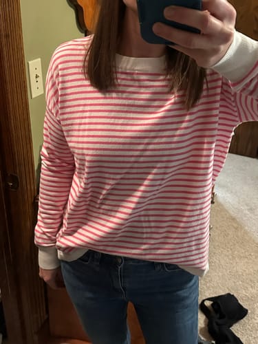 Reviewer wearing the pink and white Daybreak Stripe Sweater Tee, showing its relaxed fit with jeans.