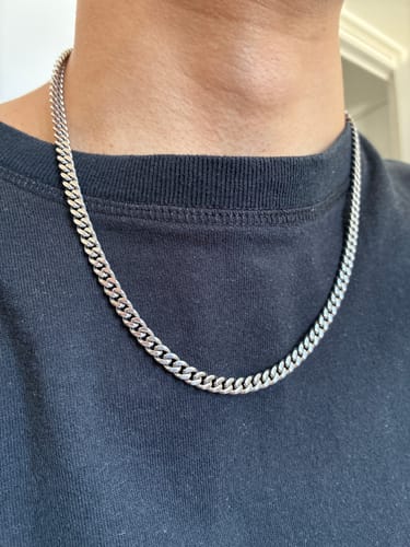 Un cliente muestra la Cadena Miami Cuban de 5mm en su cuello, sobre una camiseta oscura.