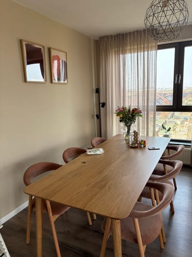 Recensent toont de eiken Brinn eettafel in een sfeervol ingerichte eetkamer.