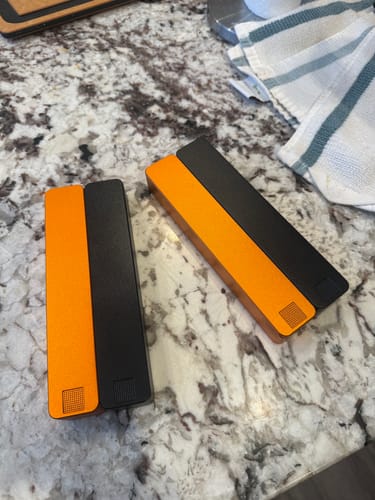 Customer's two orange and black Weekly AM-PM Pill Cases resting on a granite countertop.