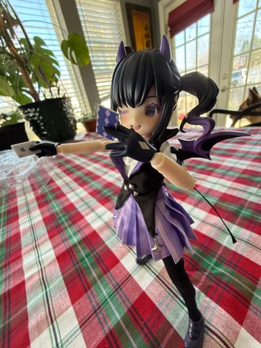 Reviewer's Light Nightmare Twins figure in a purple demon outfit, posed holding playing cards on a table.