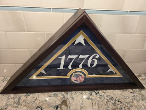 Customer's folded Betsy Ross Flag inside the triangular wood display case, showing the year 1776.