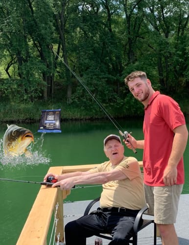 Reviewer's humorous photo of two people fishing, with packaging for Cael's Cookie and a large fish edited into the scene.