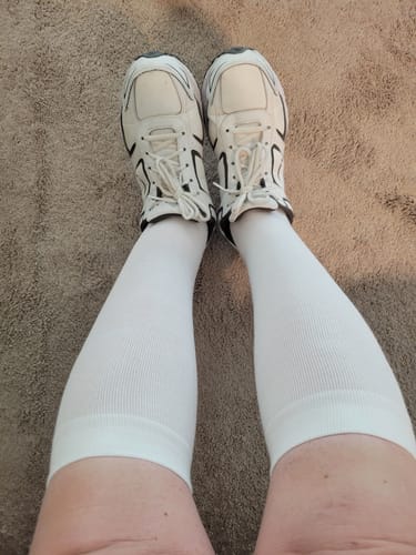 Reviewer wearing the white knee-high Performance Eucalyptus Compression Socks with athletic shoes.
