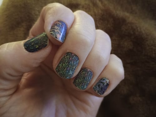 Nahaufnahme der Nägel einer Kundin mit den gemusterten Rainbow Raindrops-Folien nach fünf Tagen.