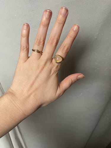 Customer's hand wearing the Populars Ring Bundle, with a triangular stone ring and a wavy band on adjacent fingers.