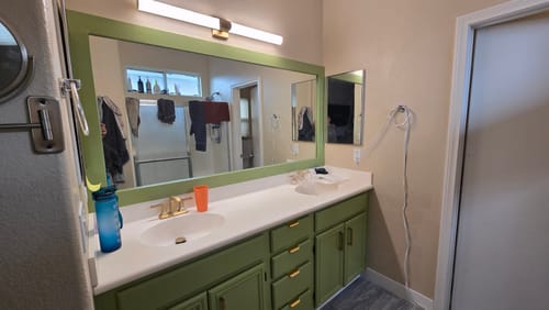 Customer's bathroom with the vanity and mirror frame painted a fresh sage green.