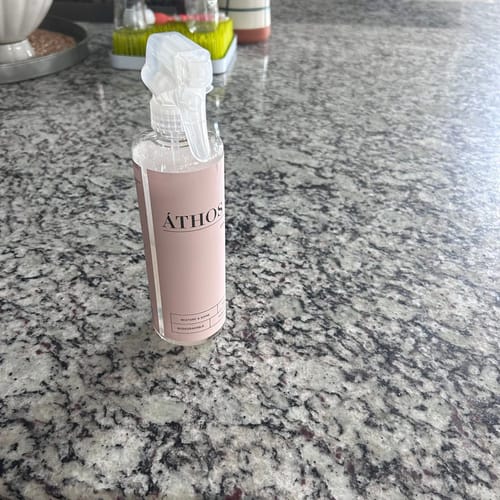 Customer's reusable Stone Shine & Polish bottle from the bundle sitting on a shiny granite countertop.