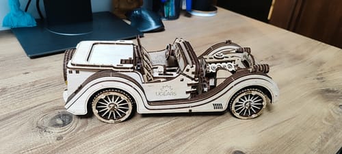 לקוח מציג את פאזל מכונית הרודסטר VM-01 שלו כמעט מורכב על שולחן עץ.