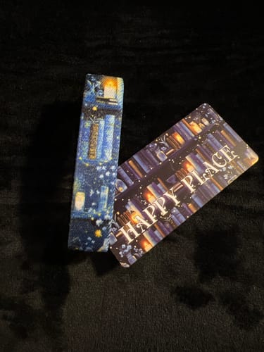 Customer's Happy Place Bracelet and card, showing its cozy, blue library design on a soft black surface.