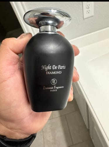 Customer holding the matte black bottle of Night de Paris Diamond perfume in their hand.