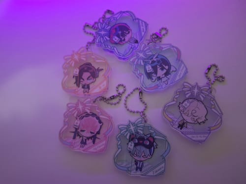 Reviewer's collection of six cute Alien Stage New Year's Eve pendants displayed under a cool purple light.